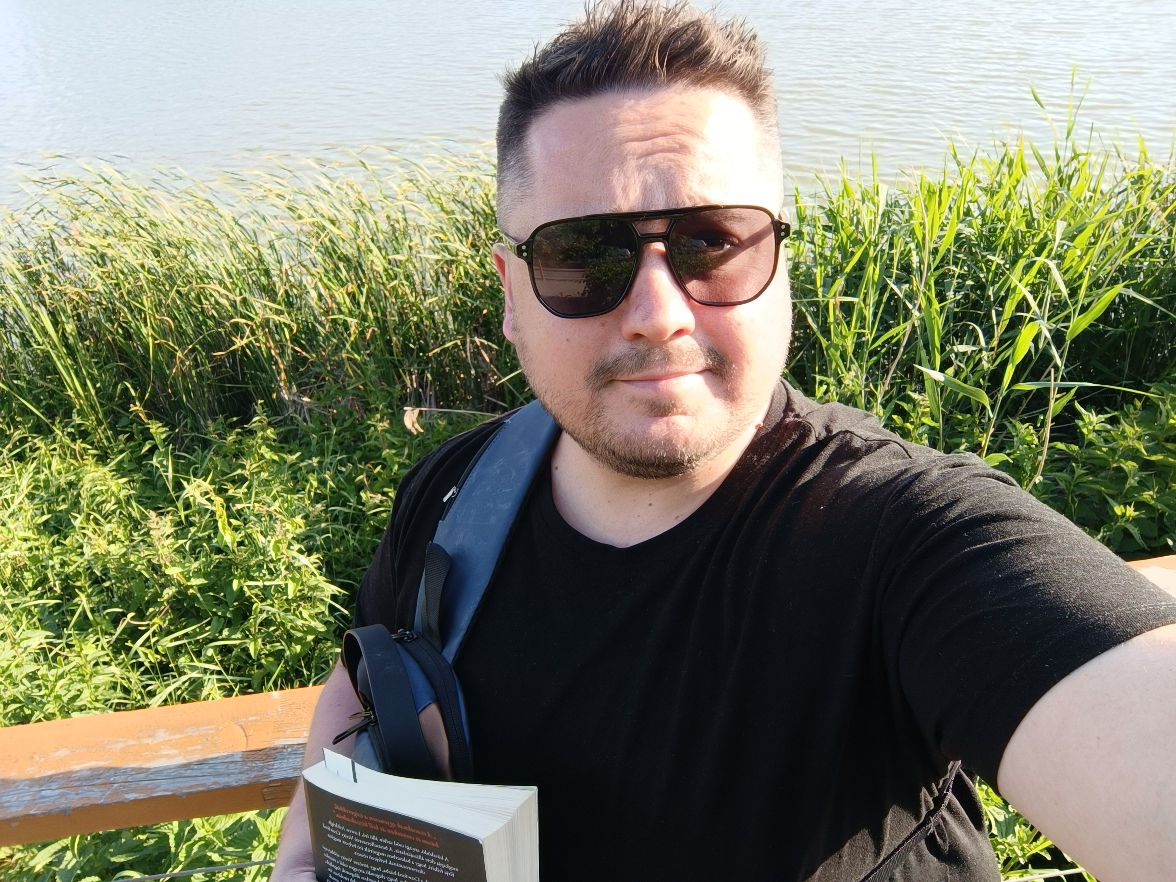 File Csaba napszemüvegben könyvvel a vízparton