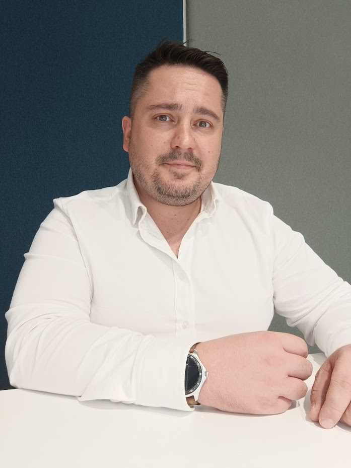 File Csaba fehér ingben, az asztalnál ülve